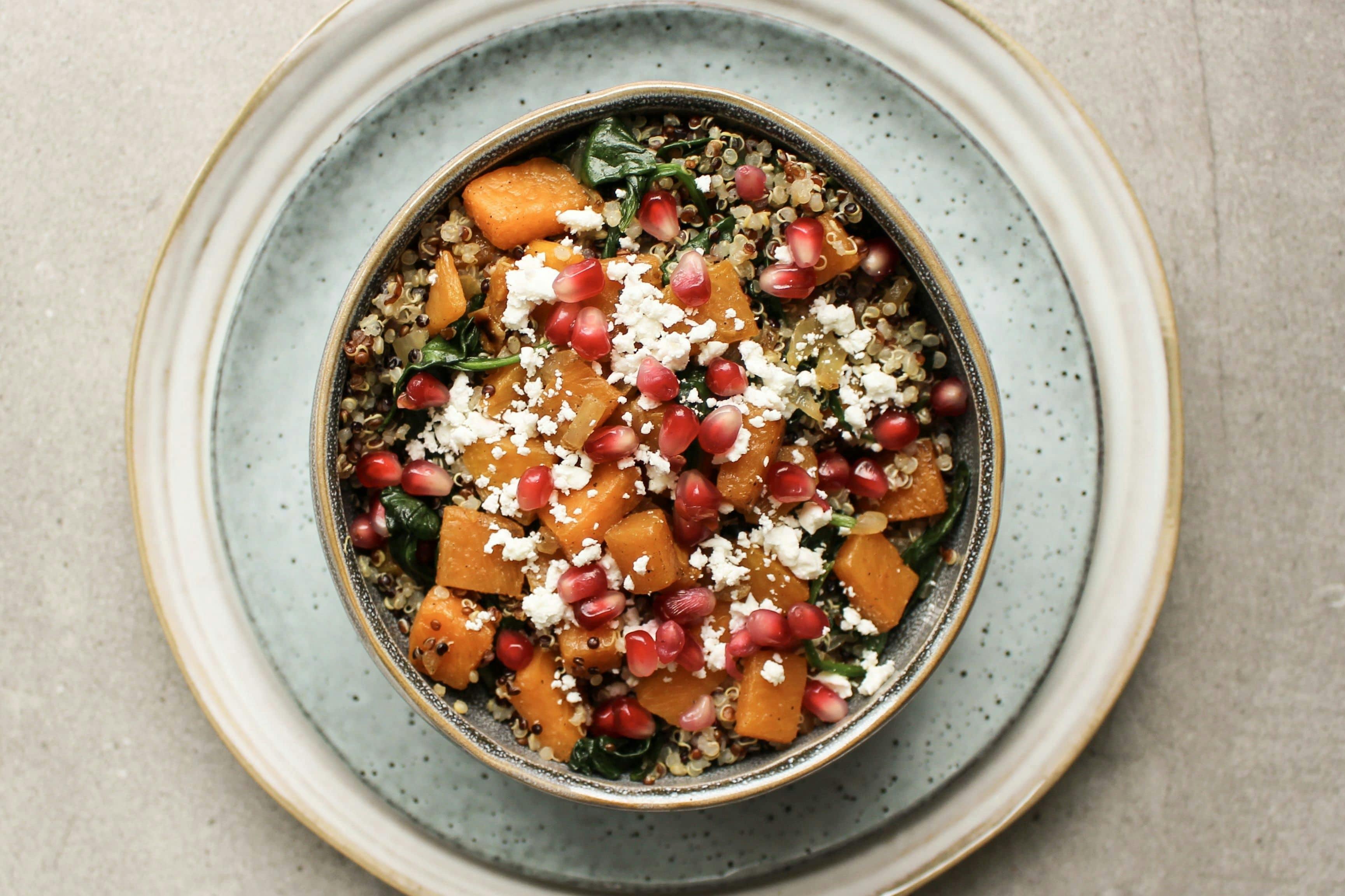 Quinoa-Winter-Bowl mit Kürbis und Granatapfelkernen in einer Schüssel