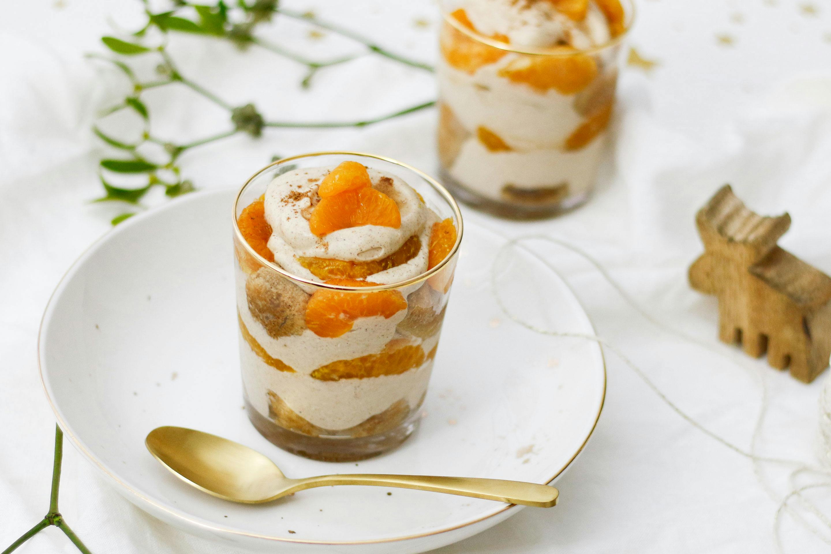 Tiramisu mit Mandarinen im Glas angerichtet mit goldenem Dessertlöffel
