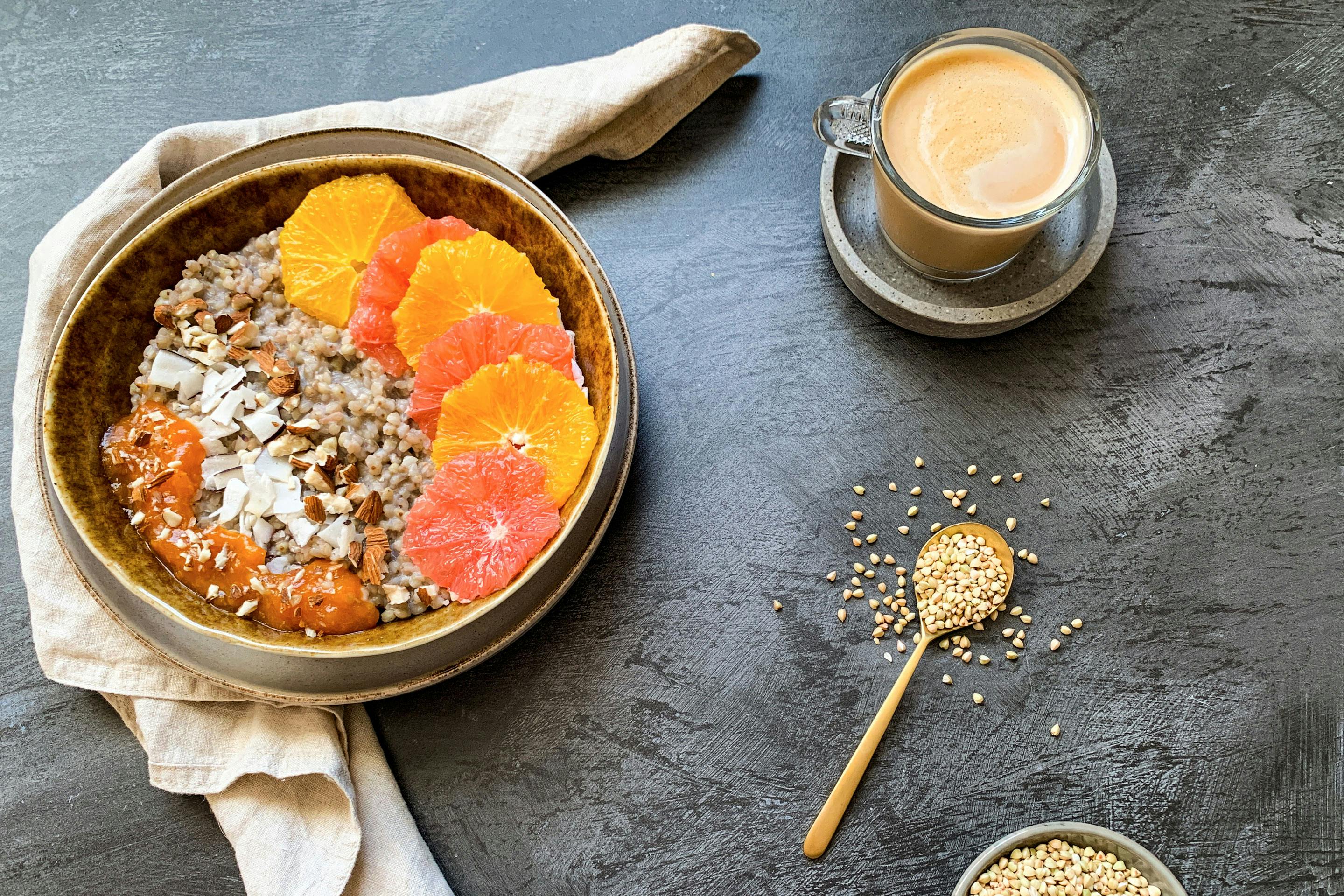 Zitrus Buchweizen-Porridge mit Orange und Grapefruit garniert und in einer Schale angerichtet
