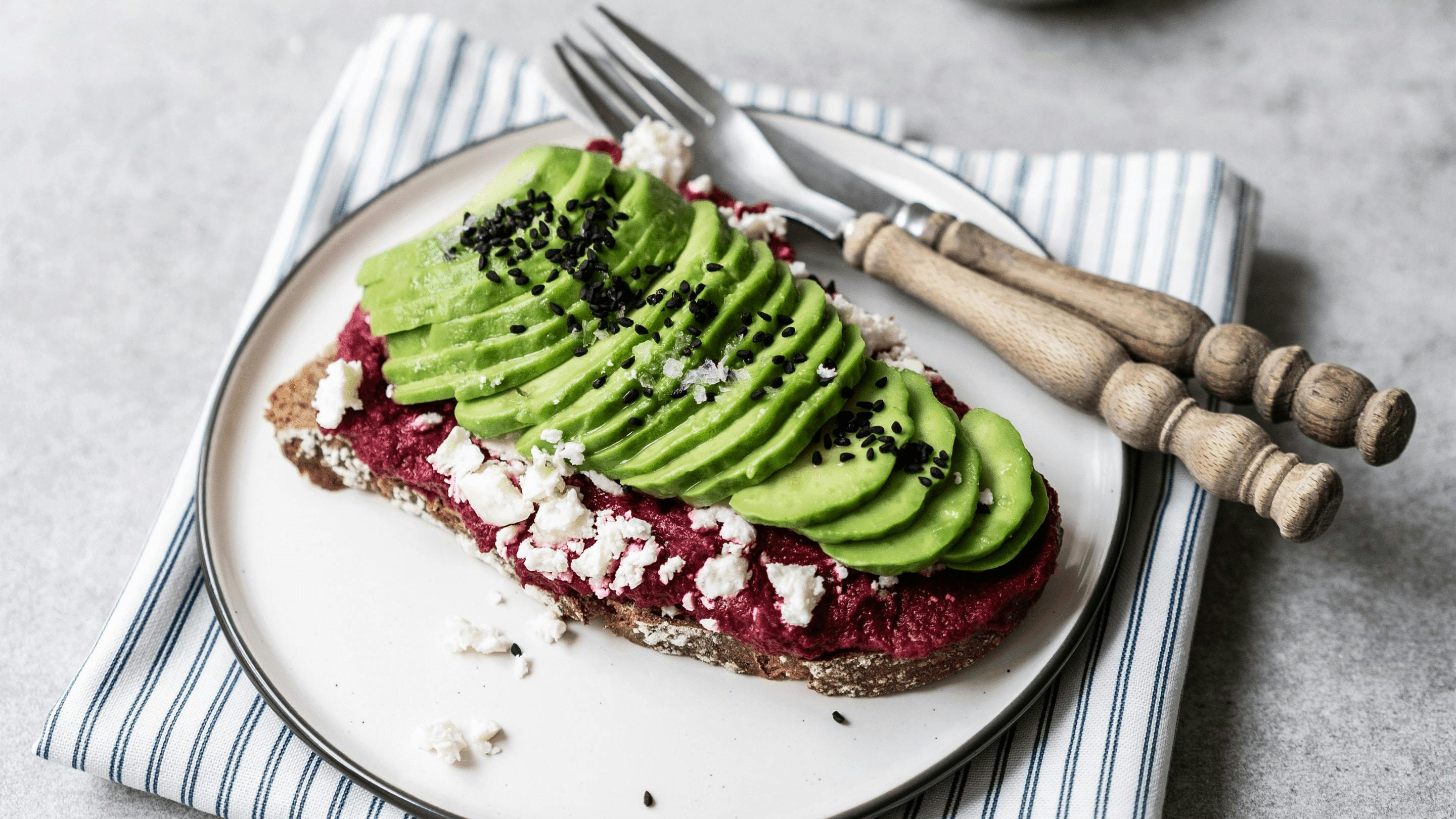 Mehrkornbrot mit Avocodo und Hummus als nahrhaftes und sättigendes Frühstück.