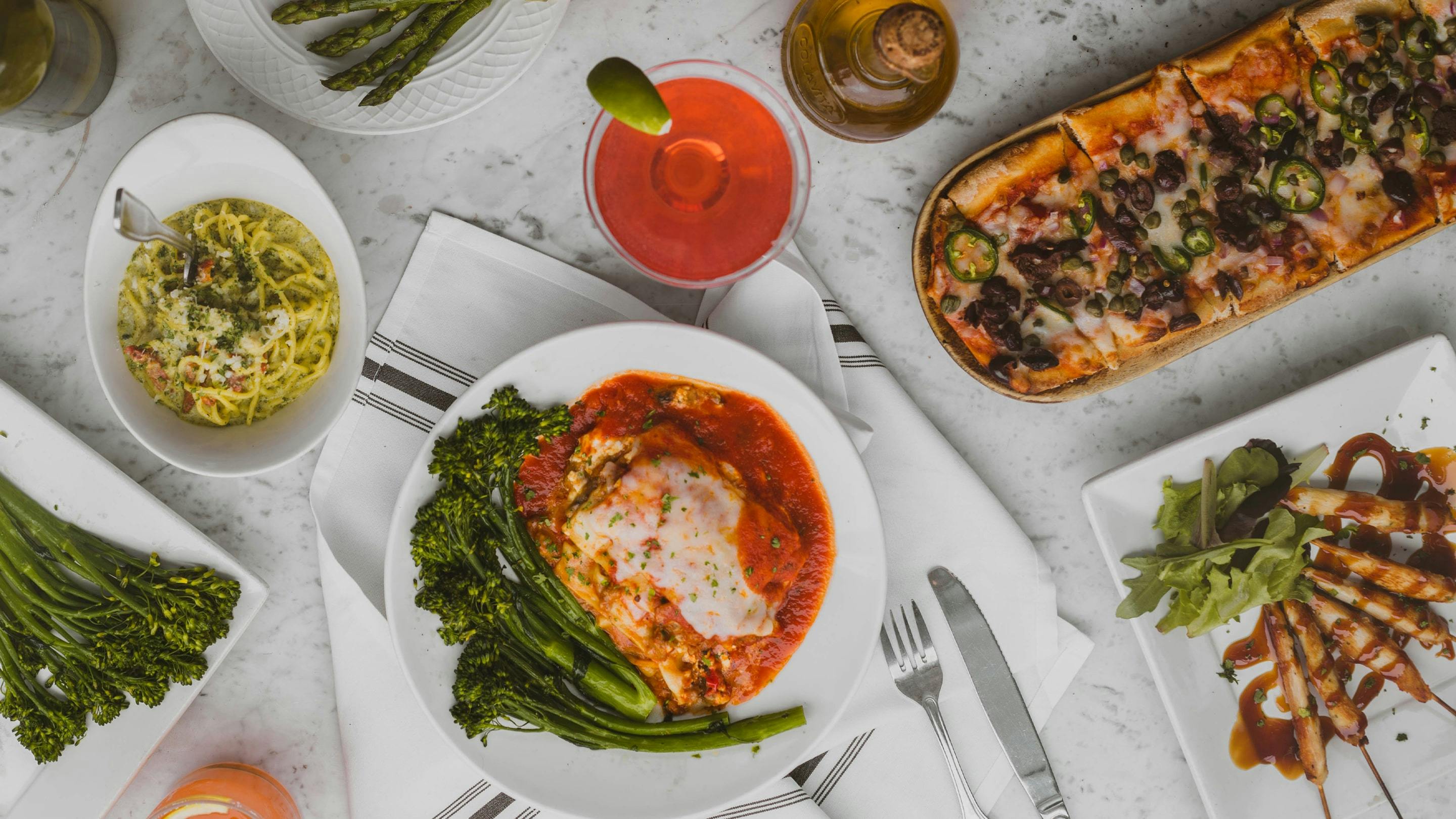 Diverse traditionelle italienische Gerichte zum Abendessen am Esstisch.