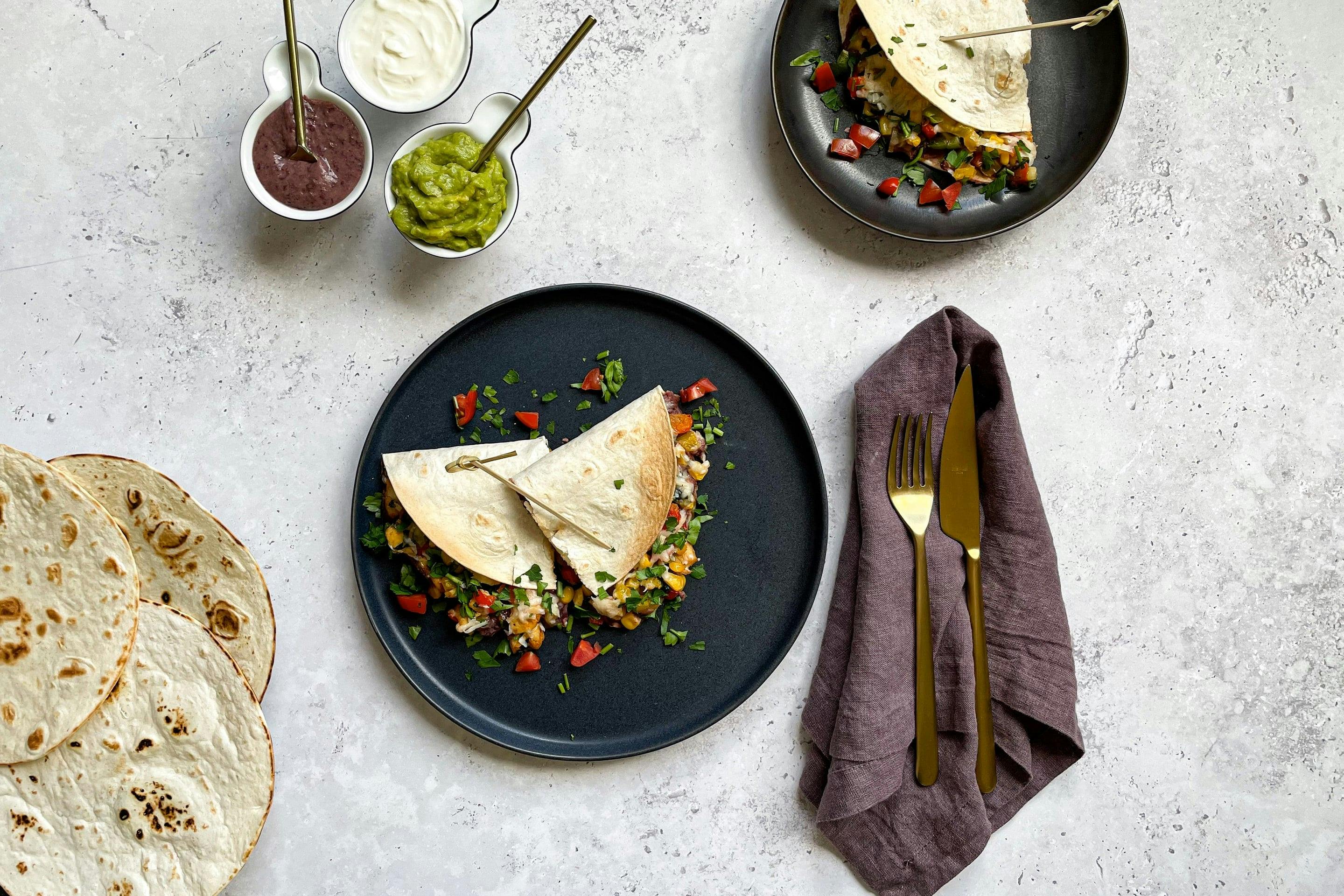 Bunte Hühnchen-Quesadillas mit Gemüse und dreierlei mexikanischen Dips.