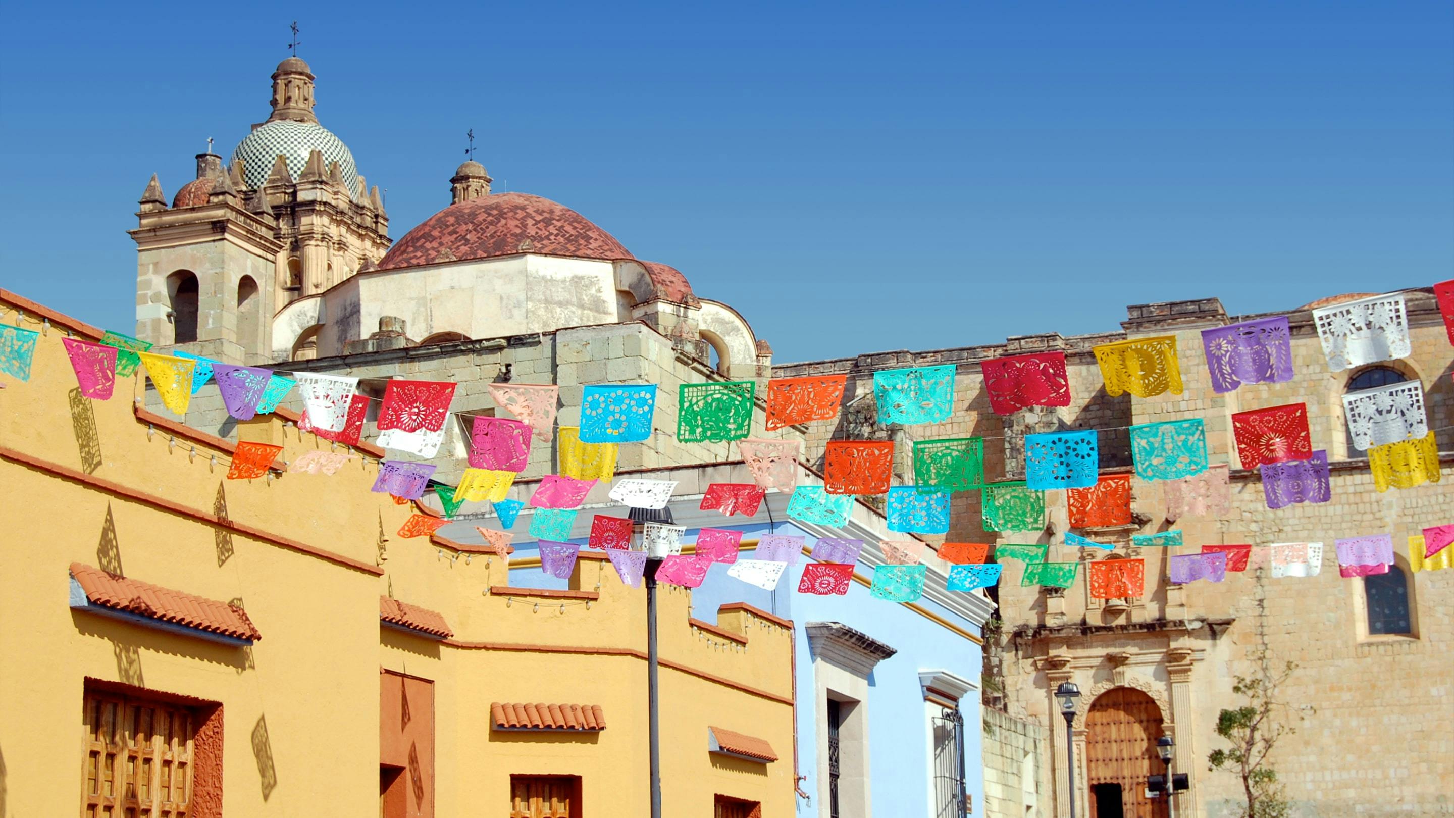 Eine Stadt in Mexiko mit vielen bunten Fahnen an den Häusern.