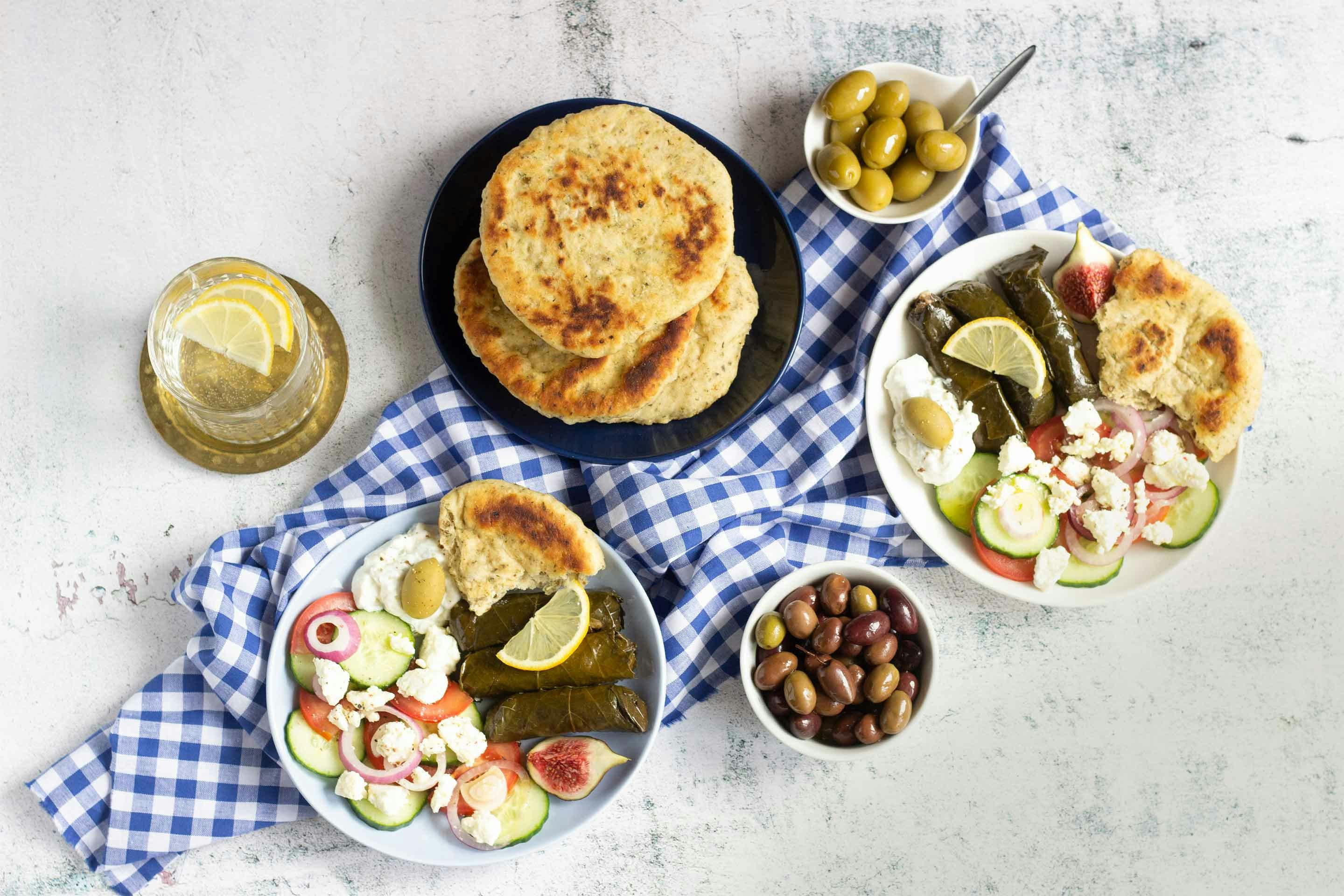Griechisches Oliven-Knoblauch-Pfannenbrot mit zwei Mezze-Teller und Oliven.